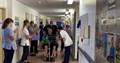 Colin Garner being wheeled by nurse, whilst nurses line up either side to say farewell